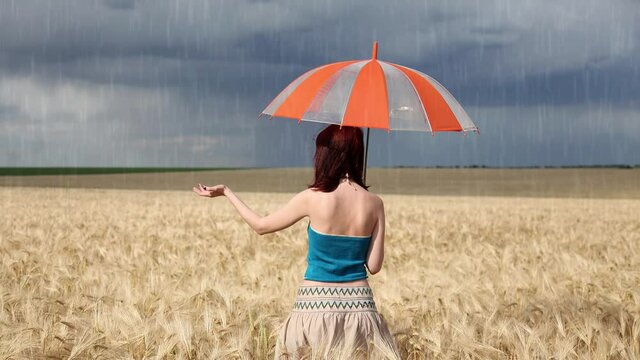 Girl with umbrella at field in retro style