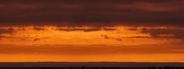 Sunset landscape in the steppe zone with a cloud hanging over the hill. Selective focus.
