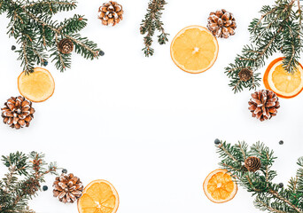Fir branches with toys and orange slices on a white background. Background for Christmas. Cones with spruce sprigs and orange