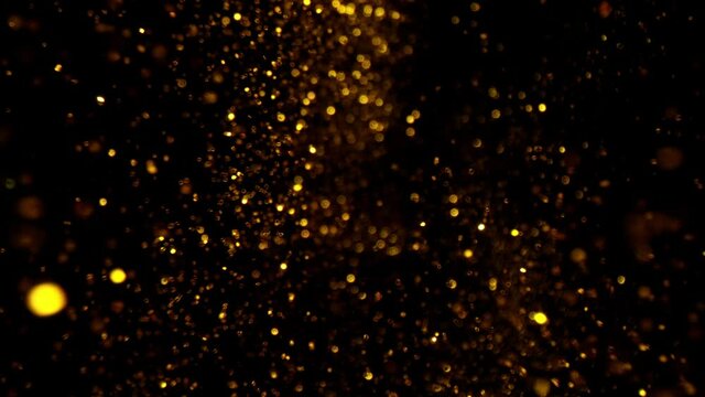 Super slow motion of abstract gold particles on black background. Filmed on high speed cinematic camera at 1000 frames per second.