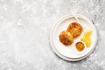 fish potato patties. with mustard sauce with lemon wedges. Top view