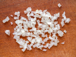 Closeup of a white onion on a wooden cutting board.