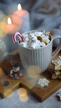 Homemade hot chocolate with marshmallow, burning candles  and gingerbread cookies