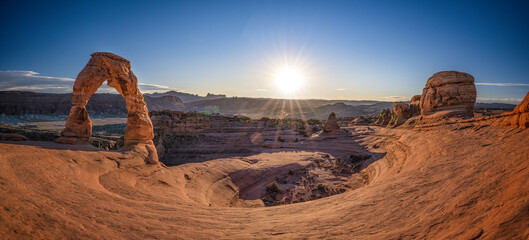 delicate arch in arches national park with sunstar