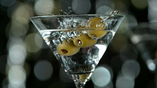 Super slow motion of falling olives into martini drink with camera motion. Filmed on high speed cinema camera at 1000 fps.
