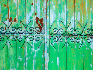 Fototapeta premium Part of a metallic green and blue fence. Colorful stains of paint and rust on the surface.