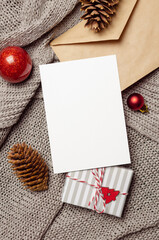 Christmas or New Year greeting card mockup with gift box, cones, envelope and festive decorations