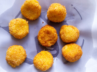 Top view of cheese balls on white paper.