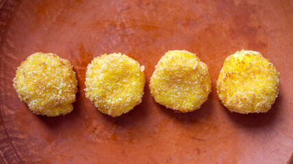 Top view of cheese croquettes on a clay plate. Delicious appetizer. 16:9