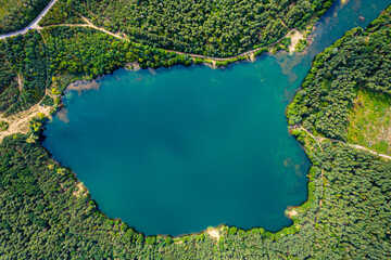 Aerial view of wild forest lake in summer. Small blue lake in gr