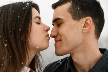 Loving couple in shirt on a winter walk. Man and woman having fun in the frosty forest. Romantic kiss in winter time.Christmas mood of a young family.Winter lovestory