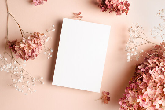 Wedding Invitation Or Greeting Card Mockup With Hydrangea And Gypsophila Flowers Decorations. Blank Card Mockup On Pink Background.