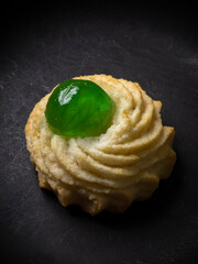 Pasticcino siciliano di pasta di mandorle e candito verde su sfondo nero