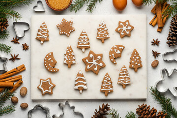 Fototapeta na wymiar Decorated homemade gingerbread cookies. Festive sweet treat on gray background, top view. Christmas composition with gingerbread pastry