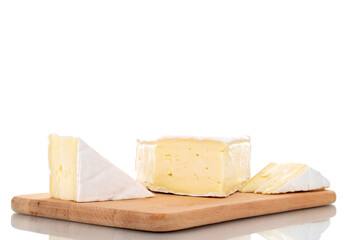 Three fragrant pieces of brie cheese on a wooden board, close-up, isolated on white.