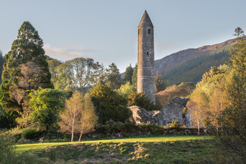 Glendalough Round tower, built of mica-slate interspersed with granite . - obrazy, fototapety, plakaty