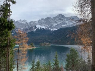 Eibsee in Autumn November with sunshine, trees and the Zugspitze mountain in the background, Bavaria Allgäu Germany	