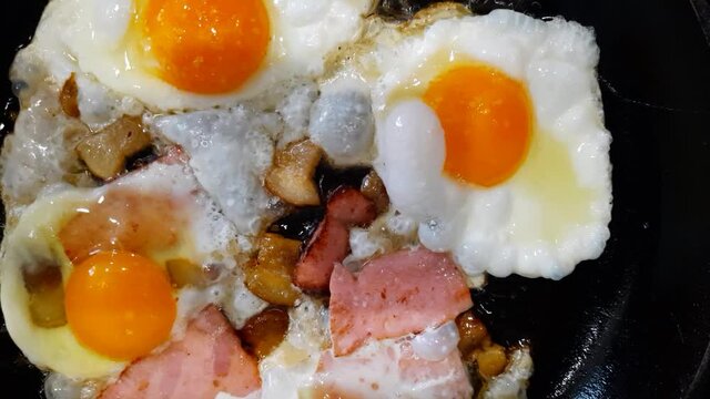 The process of cooking scrambled eggs with lard and sausage. The scrambled eggs are ready. Fried eggs with lard in a frying pan.
