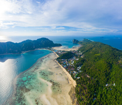 Flying above busy tropical island port filled with boats and fer