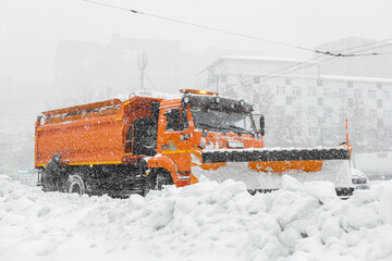 A large orange snowplow stands on the road before snow removal. Special equipment for snow removal...