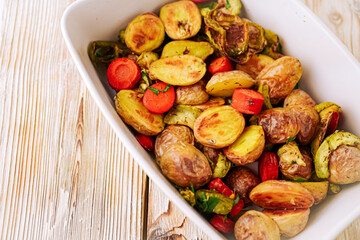 Oven baked vegetables in a baking dish. Vegetable dish close-up. Assorted vegetables roasted with spices, vegan recipe, copy space