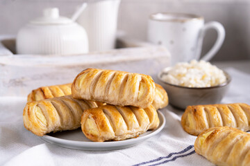 Buns with cottage cheese - puff pastry bread on white table with cup of tea, homemade country dessert, organic food, beautiful breakfast with copy paste.