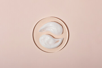 Top view of the cosmetic cream on the acrylic podium,looks like yin yang.Pastel colors,copy...