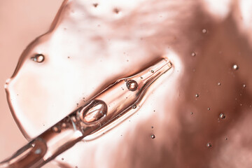 Pipette from dropper in the cosmetics gel.Top view,liquid cosmetic,macro photography.Beautiful metallic background,copy space for text.