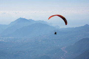 Paraglider flying over mountains