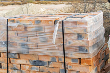 Red bricks stacked on wooden pallet