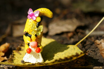 A figure of a dwarf decorated with butterflies on a yellow leaf.
