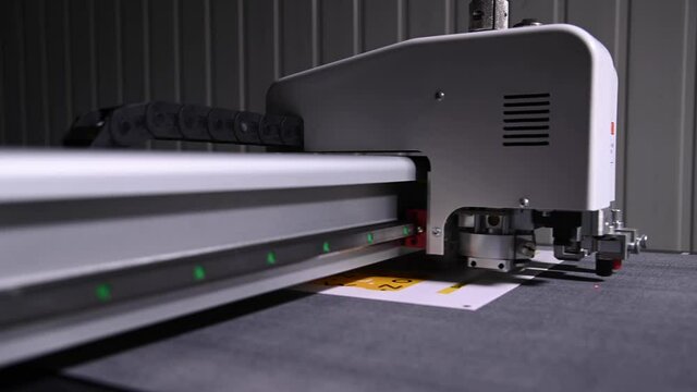 Close-up shallow depth of field a production plotter at a printing house automatically cuts packaging and labels from cardboard