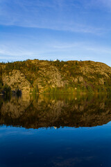 White house on top of hill with reflection in the water