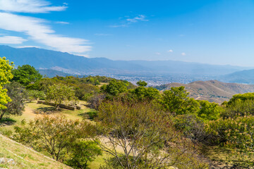 Fototapeta na wymiar Panorama view of mountainous landscapes with Oaxaca, Mexico cityscape in the background seen from Monte Alban