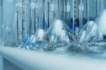 Laboratory glass flasks and test tubes on a rack.