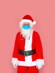 A male doctor in a Santa Claus costume wears a medical mask and a stethoscope
