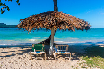 Beach beds under umbrella in caribbean beach 
