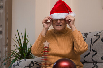 lonely senior woman with christmas santa claus hat stressed and bored