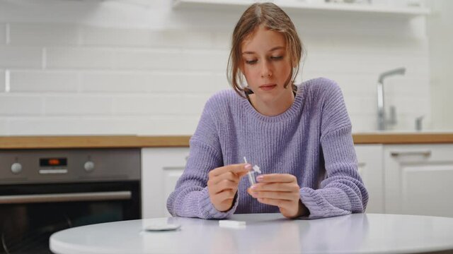 Schoolgirl doing express COVID-19 antigen test at home.
