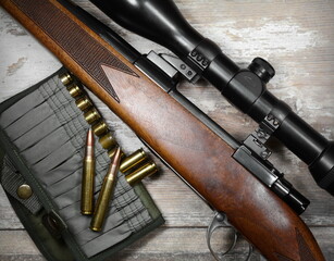 Hunting rifle and ammunition on a  wooden background.Top view.