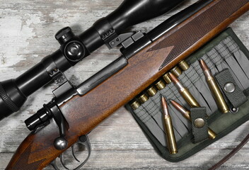 Hunting rifle and ammunition on a  wooden background.Top view.