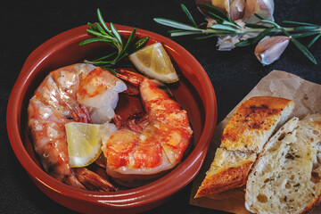 Scampi, Prawns, Gambas delicate Seafood, Tapas on a dark table 