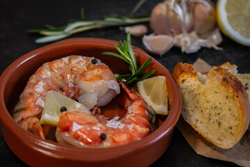 Scampi, Prawns, Gambas delicate Seafood, Tapas on a dark table 
