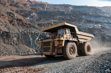 open cast mine dump trucks drive alone industrial area of iron ore quarry