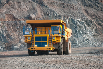 open cast mine dump trucks drive alone industrial area of iron ore quarry