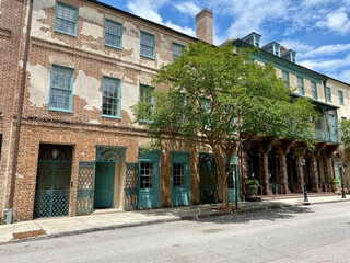 Fototapeta na wymiar Charleston, South Carolina, USA: Dock Street Theatre in the historic downtown French Quarter. Brick with wrought iron balcony and sandstone columns. America’s first theater.