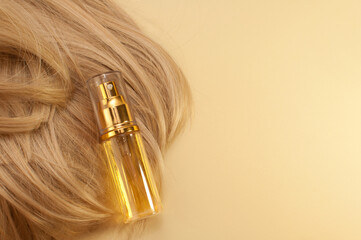 Obraz premium hair oil on blonde hair on beige background with space for text