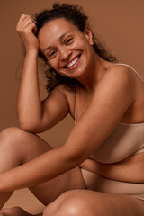 Fototapeta na wymiar Attractive nude woman in underwear smiles toothy smile looking at camera. Body positivity, self-acceptance and confidence, body love concept with copy ad space