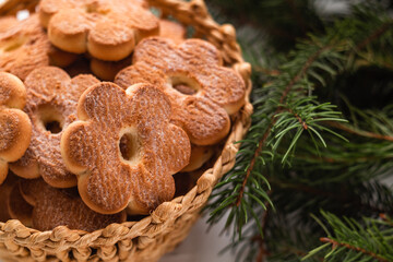 Christmas shortbread cookies close up in a wicker basket and branches of a Christmas tree. Flower...