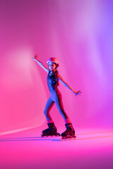 child athlete skater with open arms training with safety equipment for competition, looking at photo, on pink background in a studio